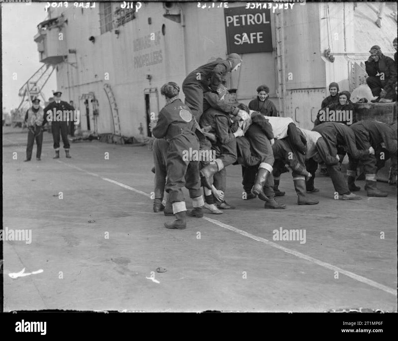 The Royal Navy during the Second World War With the men climbing on top of one another, memories of school days are harked back to during 'stand easy' for the flight deck party on board the light fleet carrier HMS VENGEANCE in the Clyde during aircraft trials. Stock Photo