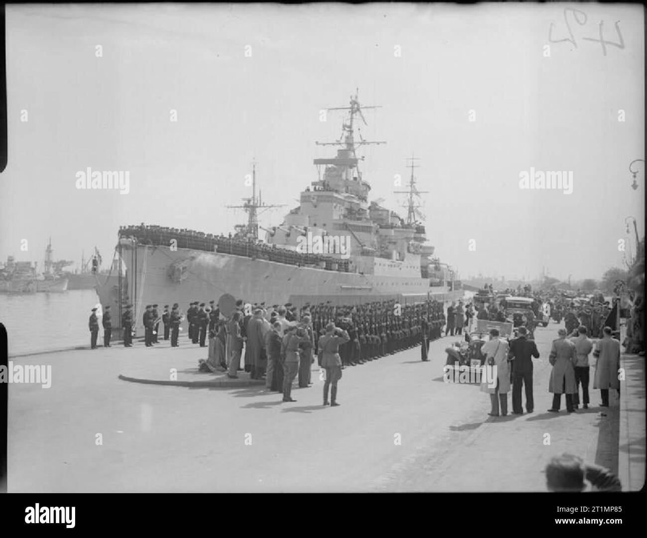 The Royal Navy during the Second World War Field Marshal Montgomery saluting from his car while passing down a quayside lined with a Royal Marine Guard of Honour from HMS BIRMINGHAM. The Field Marshal had just landed at Copenhagen, Denmark following its liberation by British forces. HMS BIRMINGHAM is moored to the quayside and her crew line the decks. Stock Photo