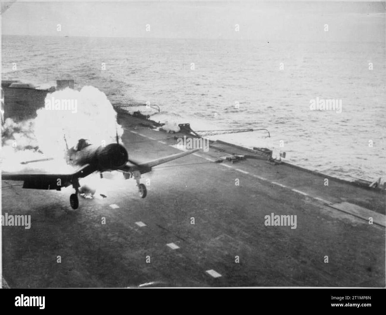 The Royal Navy during the Second World War On board a British Pacific fleet carrier operating against the Japanese. Lieutenant Commander (A) Freddy Charlton, British Fleet Air Arm pilot, had a remarkable escape when the long-range petrol tank of his Chance-Vought Corsair fighter burst into flames (seen here) as he landed on the deck of the aircraft carrier. Both pilot and plane escaped damage. Stock Photo