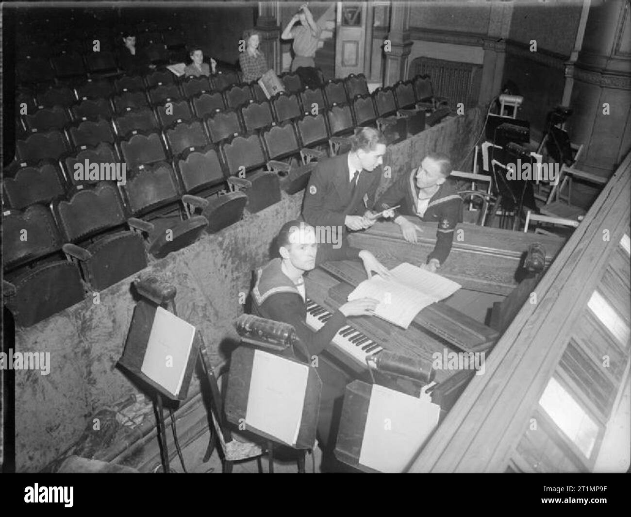The Royal Navy during the Second World War Sat in the orchestra pit with their instruments are the trio of, left to right: Telegraphist Tony Fones; Sick Berth Attendant Denis Cockerton and Leading Seaman Bobby Pagan, who will accompany the show and are featured in the London production of the all navy show 'Pacific Show Boat' at the Lyric Theatre, Hammersmith. The show is being sent by Amenities Ships to the Pacific to entertain personnel of the British Pacific Fleet after its London run. Costumes and decor are by Sub Lieutenant Hedley Briggs and the musical numbers by Lieutenant Ronnie Hill. Stock Photo