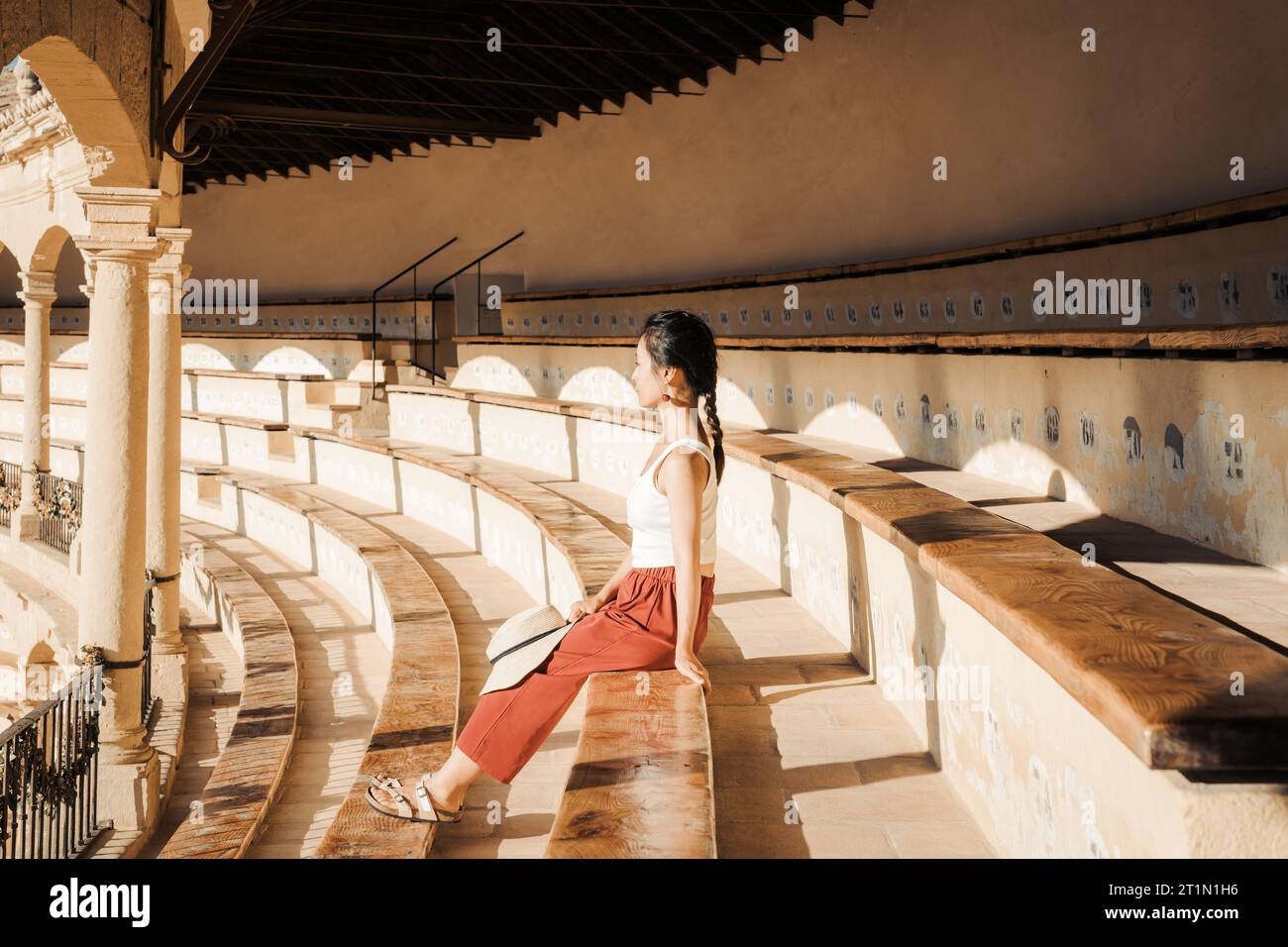 A woman sitting on the seat in the Plaza de Toros de Ronda, a historic Bullring in Ronda, Spain Stock Photo