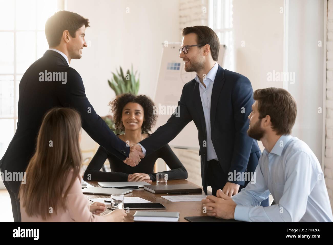 Two successful managers men in formal jackets greeting each other Stock Photo