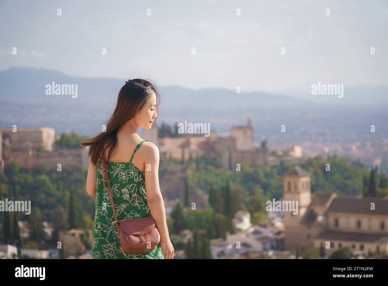 A woman standing on the mountain top looking over the Alhambra, Granada, Spain Stock Photo