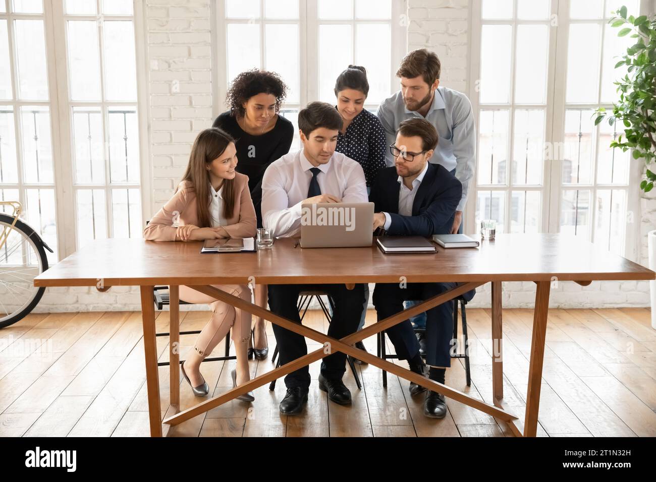 Diverse managers meeting at table with laptop, using modern technology Stock Photo