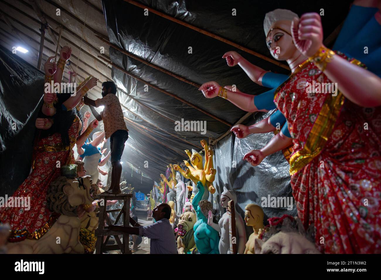 New Delhi, India. 14th Oct, 2023. An artist is observed adorning the clay idol of Goddess Durga in preparation for the upcoming Durga Puja festival at Sarojini Nagar Kalibari Temple. Durga Puja is a Hindu festival celebrated mainly in West Bengal and by Bengali communities worldwide. It's a multi-day celebration dedicated to Goddess Durga, symbolizing divine feminine power and the victory of good over evil. (Photo by Pradeep Gaur/SOPA Images/Sipa USA) Credit: Sipa USA/Alamy Live News Stock Photo