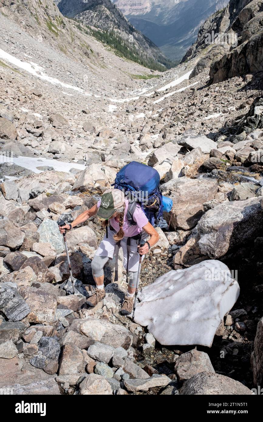 WY05467-00....WYOMING - Senior woman asending Cube Rock Pass while hiking the Glacier Trail/Continental Divide Trail in the Bridger Wilderness, Bridge Stock Photo
