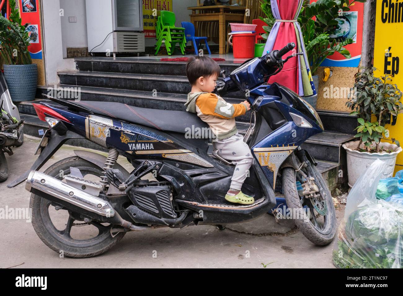 Cat Ba, Vietnam. Young Boy Exploring Motorbike. Stock Photo