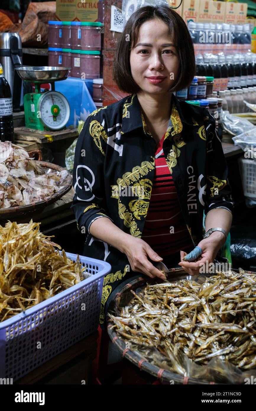 Cat Ba, Vietnam. Shopkeeper in the Market Preparing Dried Fish for Sale. Stock Photo
