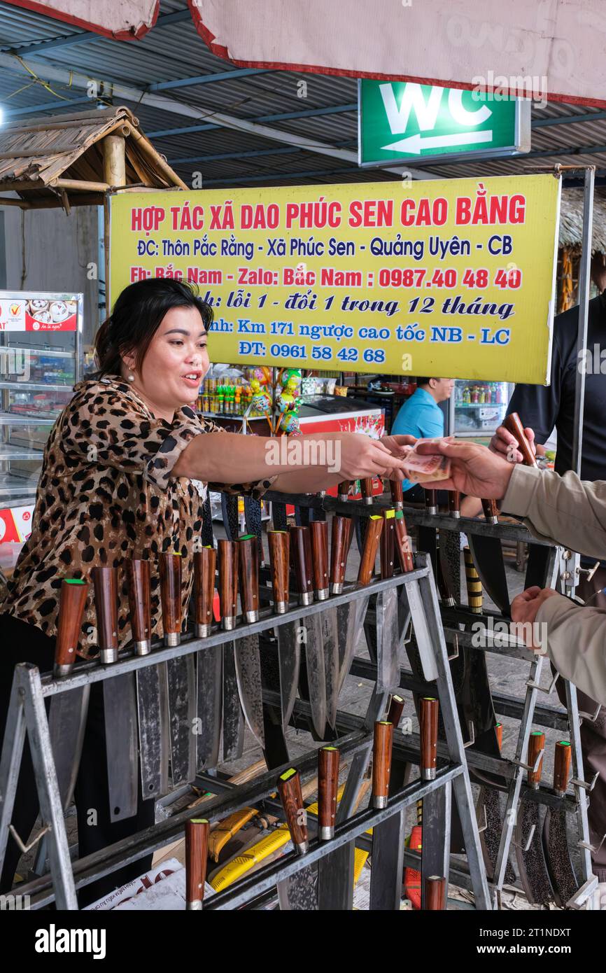 Woman Selling Knives at Roadside Rest Stop between Hanoi and Lao Cai, Vietnam. Stock Photo