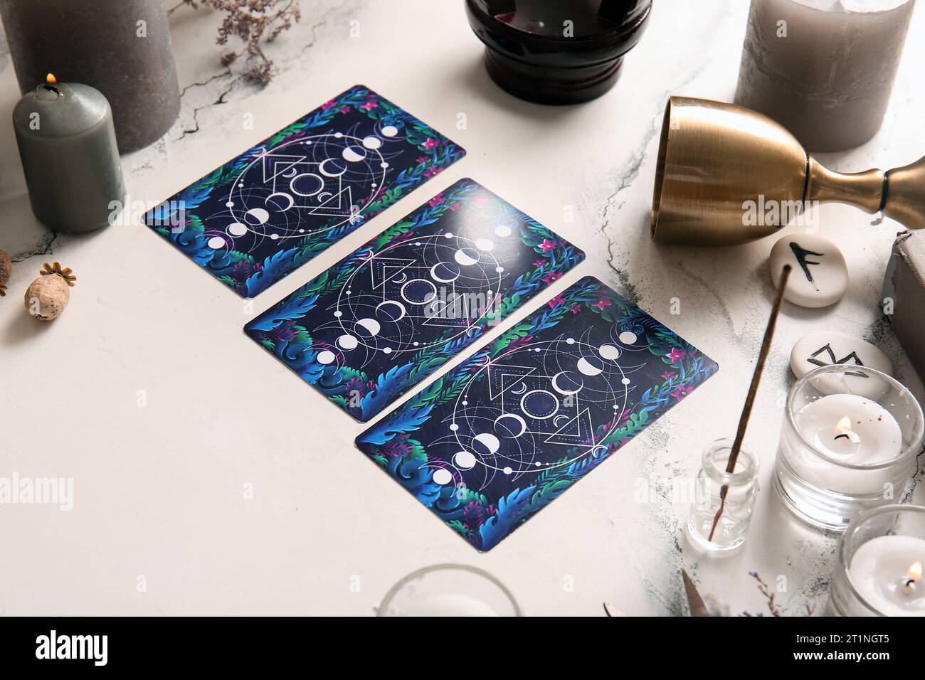 Witch's magic attributes with tarot cards on light background, closeup ...