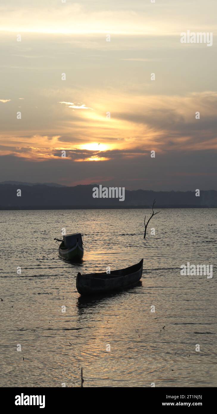 Silhouette of a boat in the sea at sunset Stock Photo - Alamy