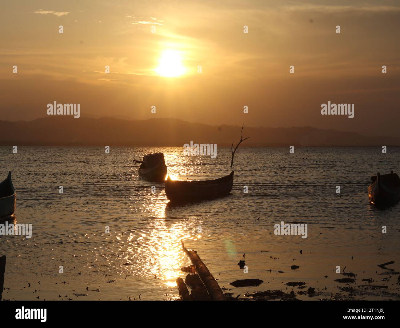 Silhouette of a boat in the sea at sunset Stock Photo - Alamy