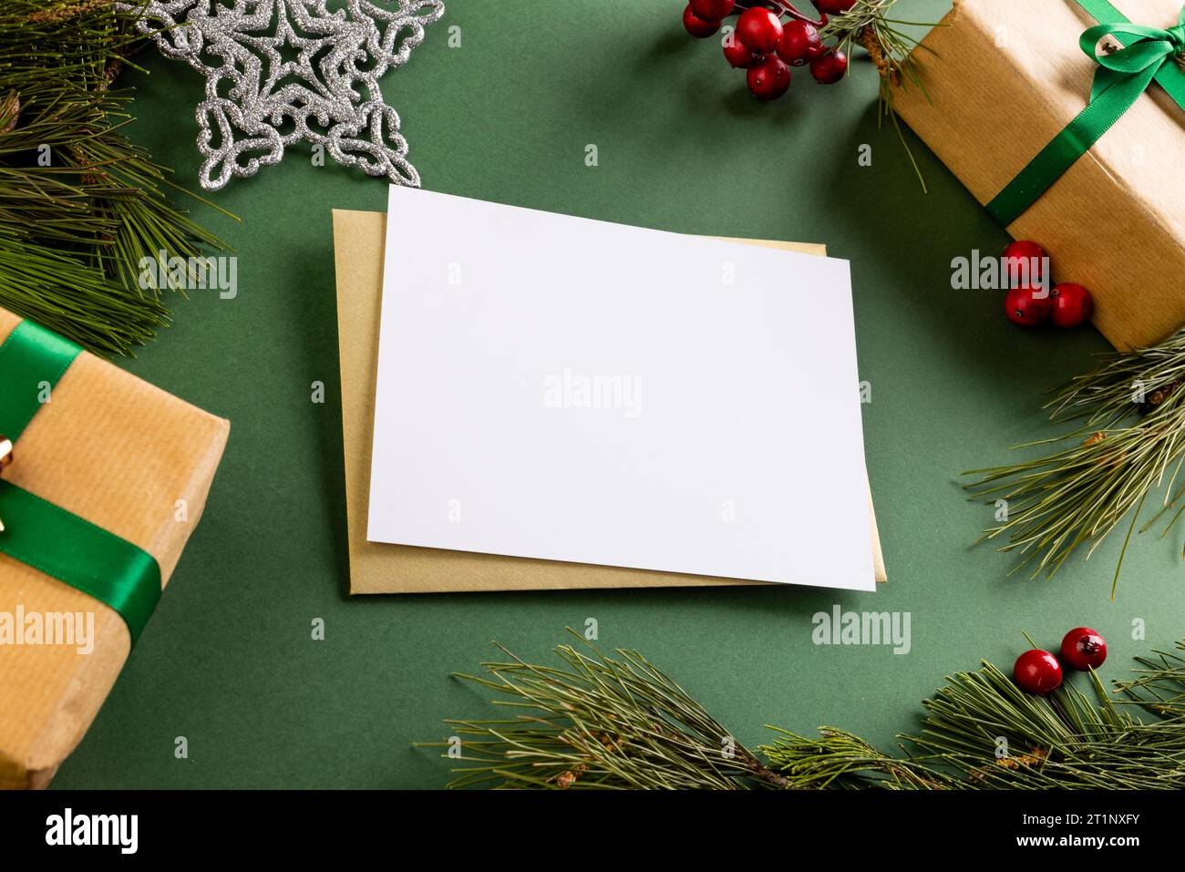 Christmas decorations and white card with copy space on green background Stock Photo