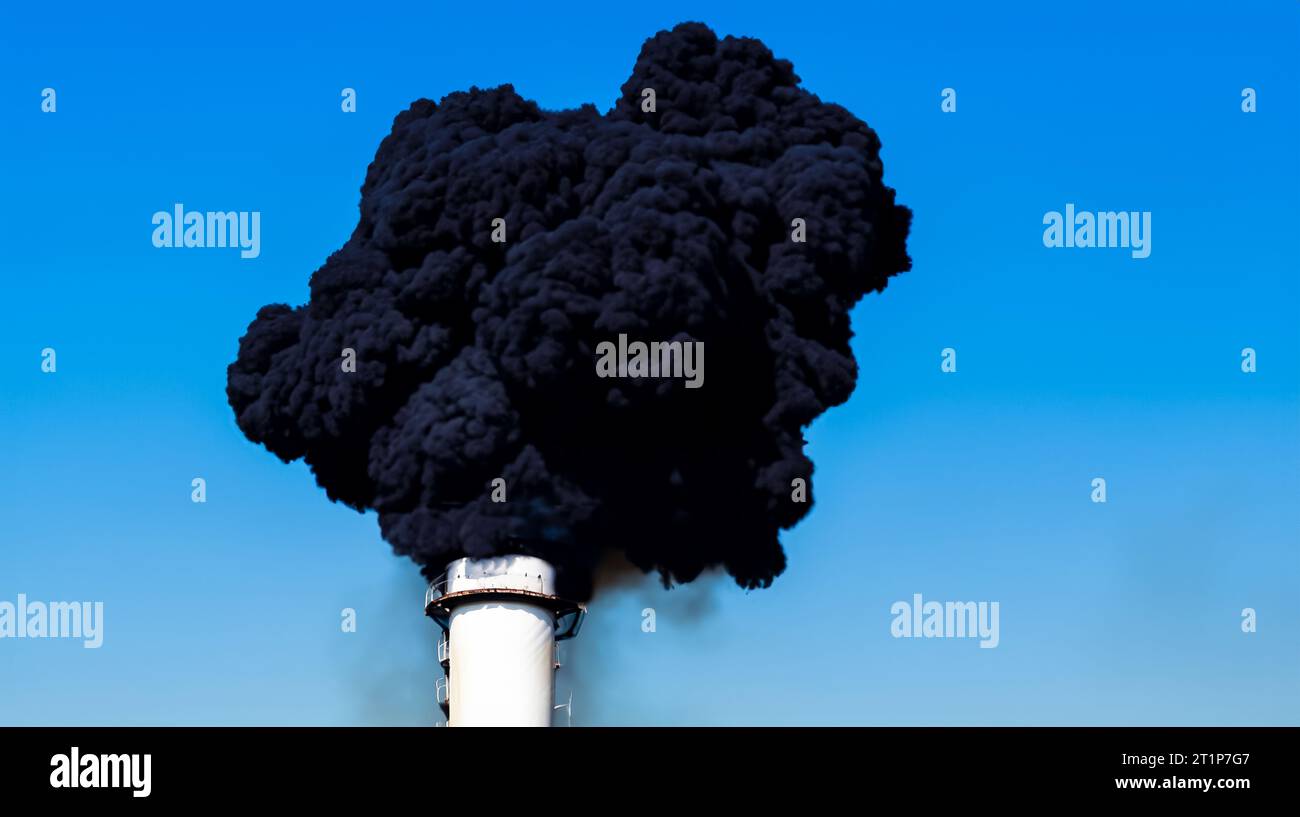 Chimney of the industrial plant emitting dense black smoke very