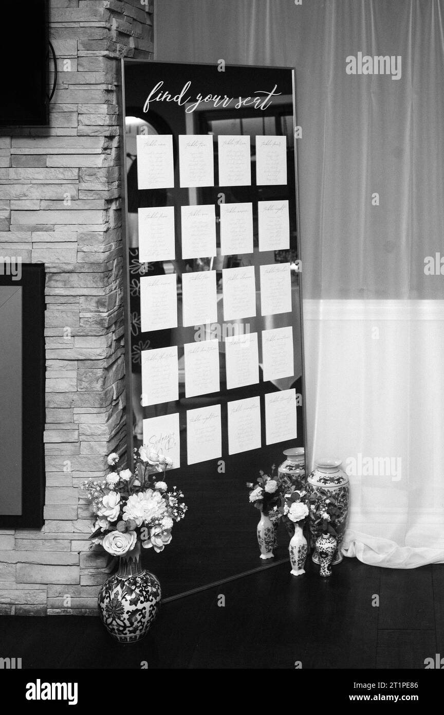 A full-length mirror displaying a detailed seating chart for a wedding reception Stock Photo