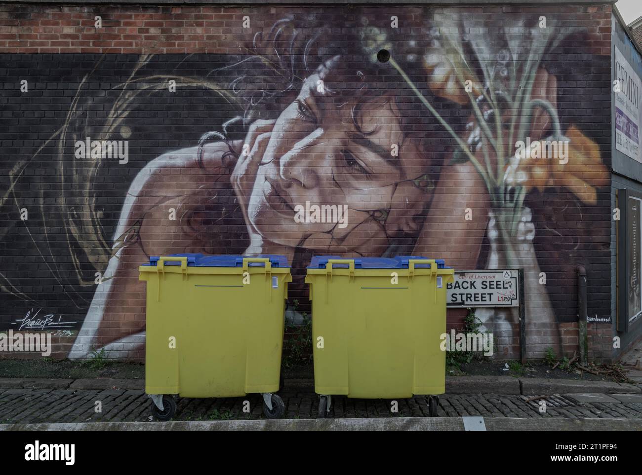 Liverpool, UK Oct 09, 2023 Two yellow Wheelie bin front of Portrait