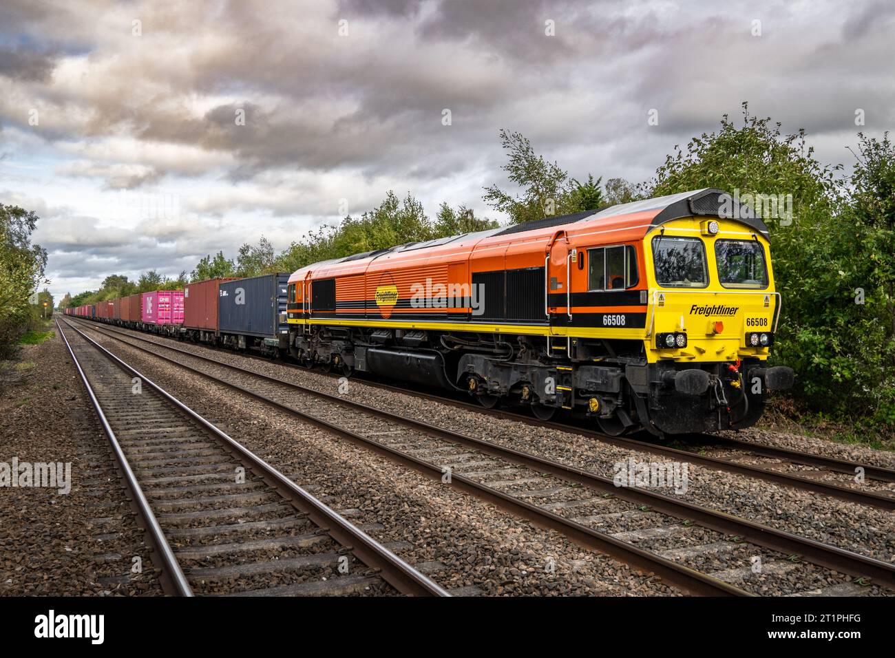 DERBY, UK - OCTOBER 6, 2023.  A Freightliner Intermodal Class 66 freight train with container box on a main line railway painted in the parent company Stock Photo
