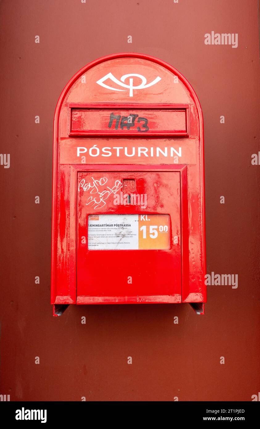 Íslandspóstur or Pósturinn Red Iceland Post Box Wall Mounted With Some Graffiti Tagging On The Postbox Reykjavik Icelandic Mail Letter Service Stock Photo