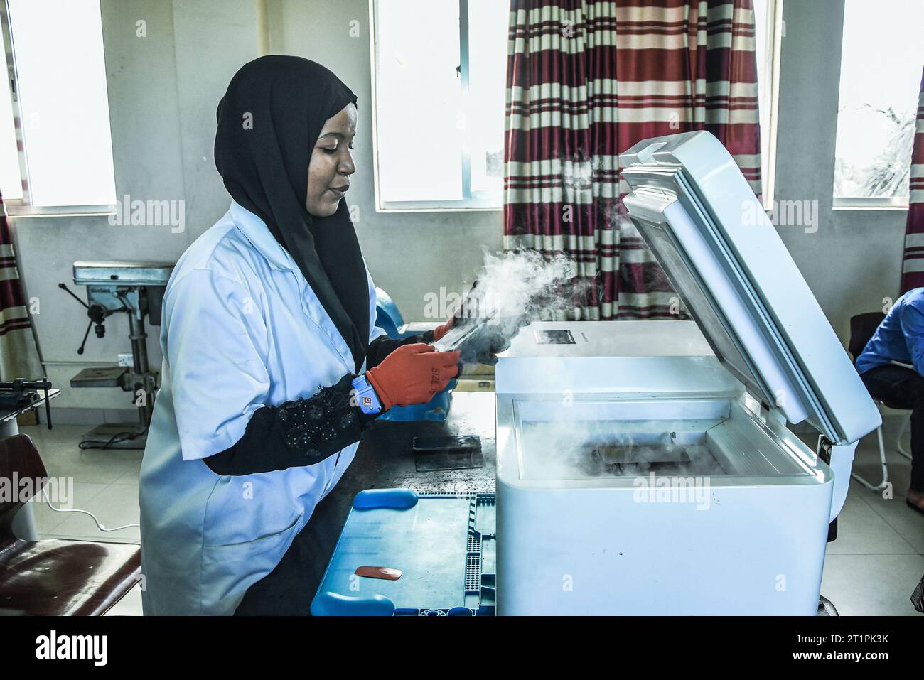 A young female technician at the Vocational training centre repairing a mobile phone in Dar es Salaam, Tanzania on October 1, 2021 Stock Photo