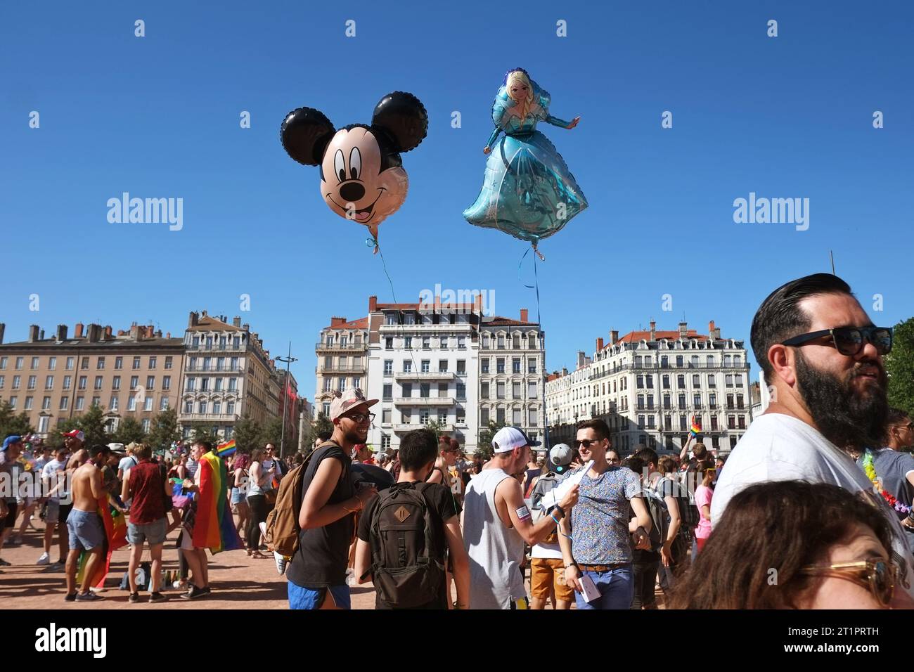 Micky Mouse and Disney Princess balloons float above a PRIDE March, lgbtqi+ people and celebrations in Place Bellecour,  Lyon, France Stock Photo