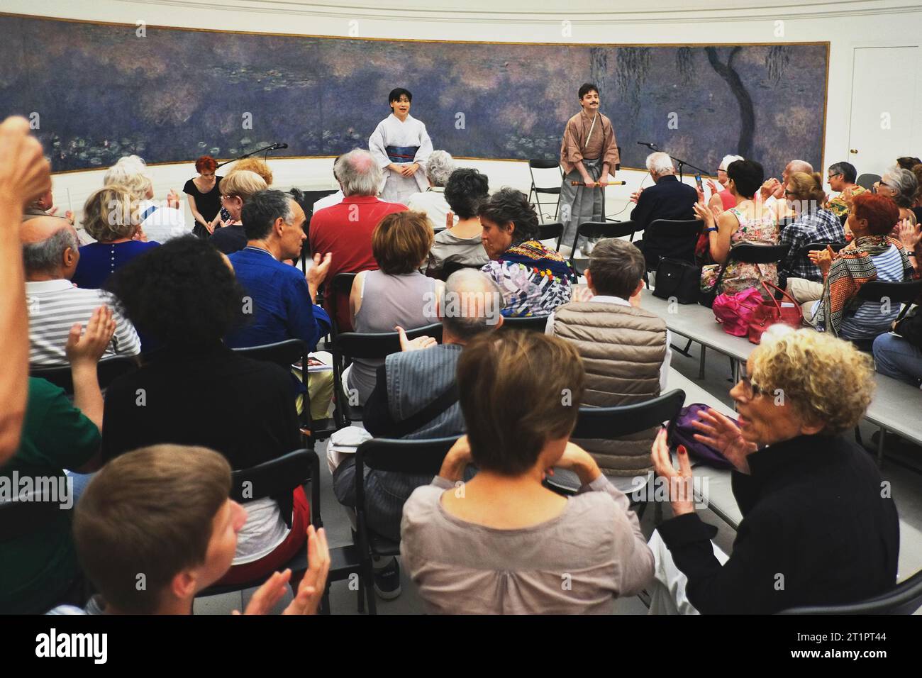 After the concert music, a music recital in Paris at the Musée de l'Orangerie with waterlily paintings by Monet, performers taking a bow audience Stock Photo