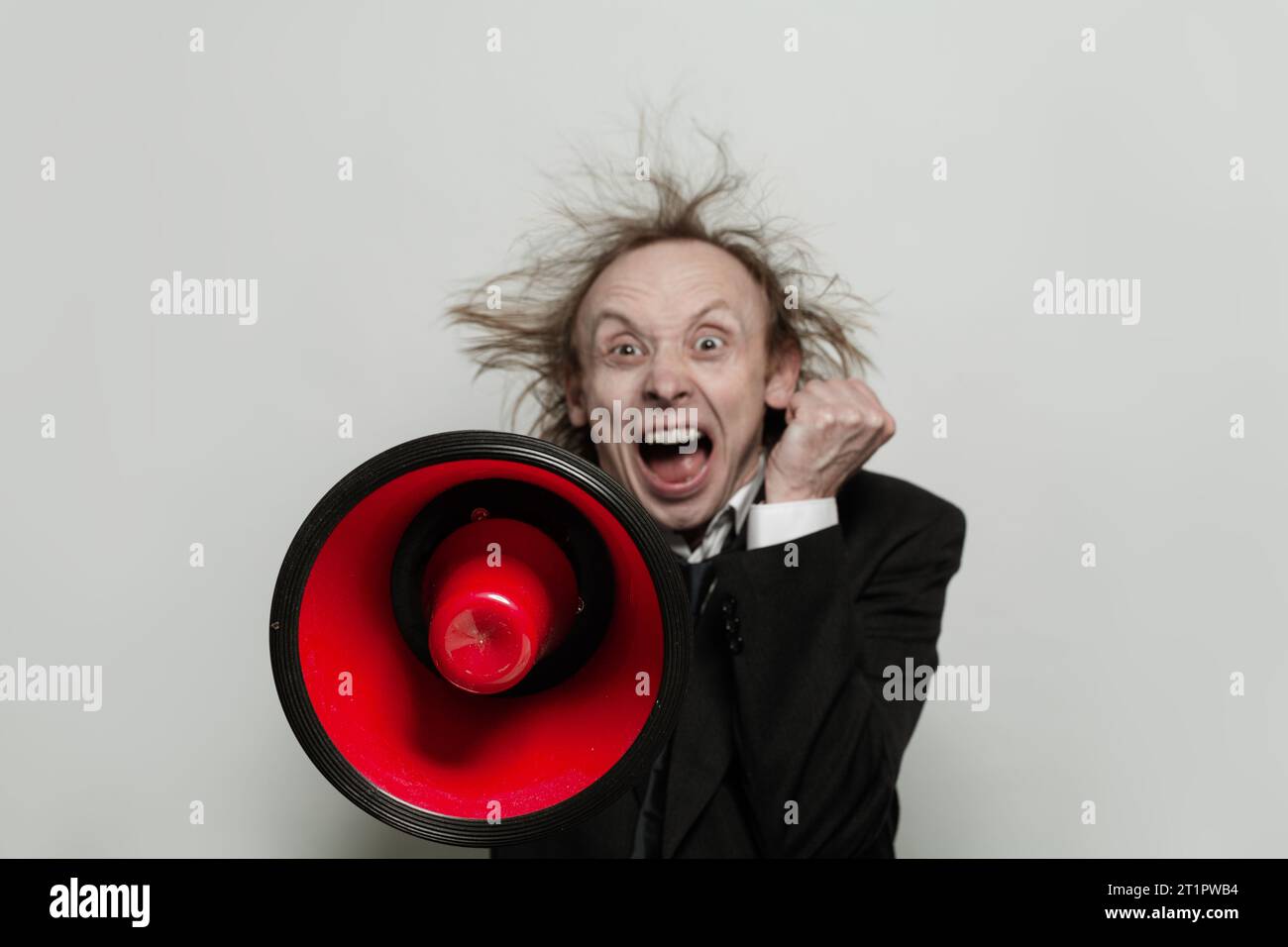 Angry businessman holding loudspeaker and screaming on white background ...