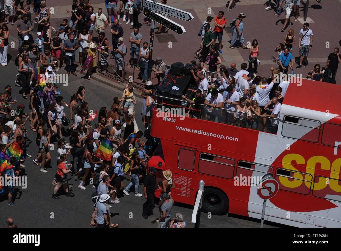 Aerial view of a Pride march in Lyon, people waking behind double decker party bus with a DJ, Radio Scoop, gay rights seen from above, in Lyon France. Stock Photo
