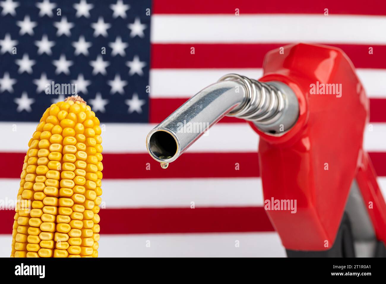 Gas dripping from fuel nozzle with American flag and ear of corn. Gasoline shortage, price and