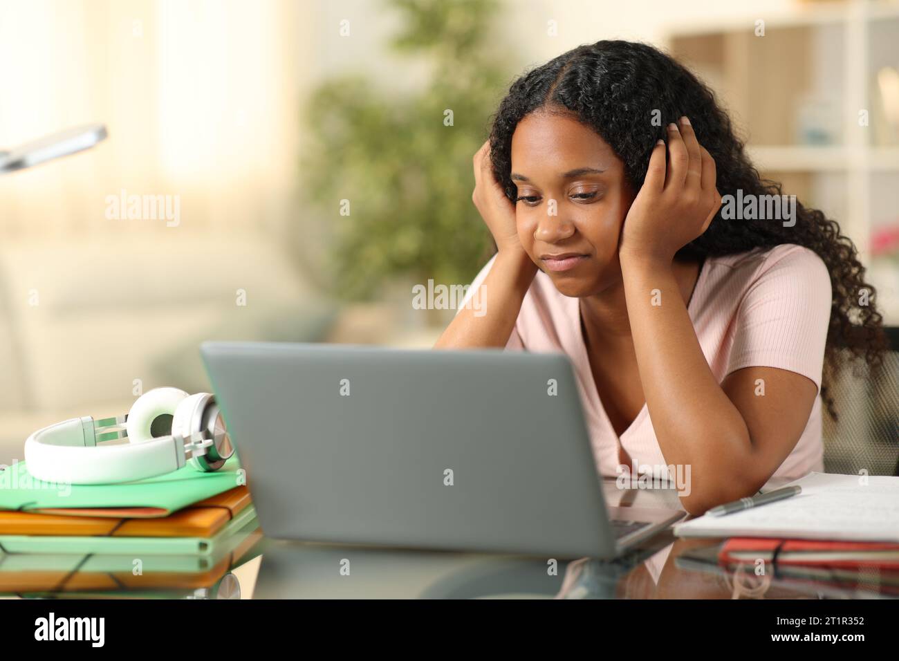 Disappointed black student checking laptop at home Stock Photo