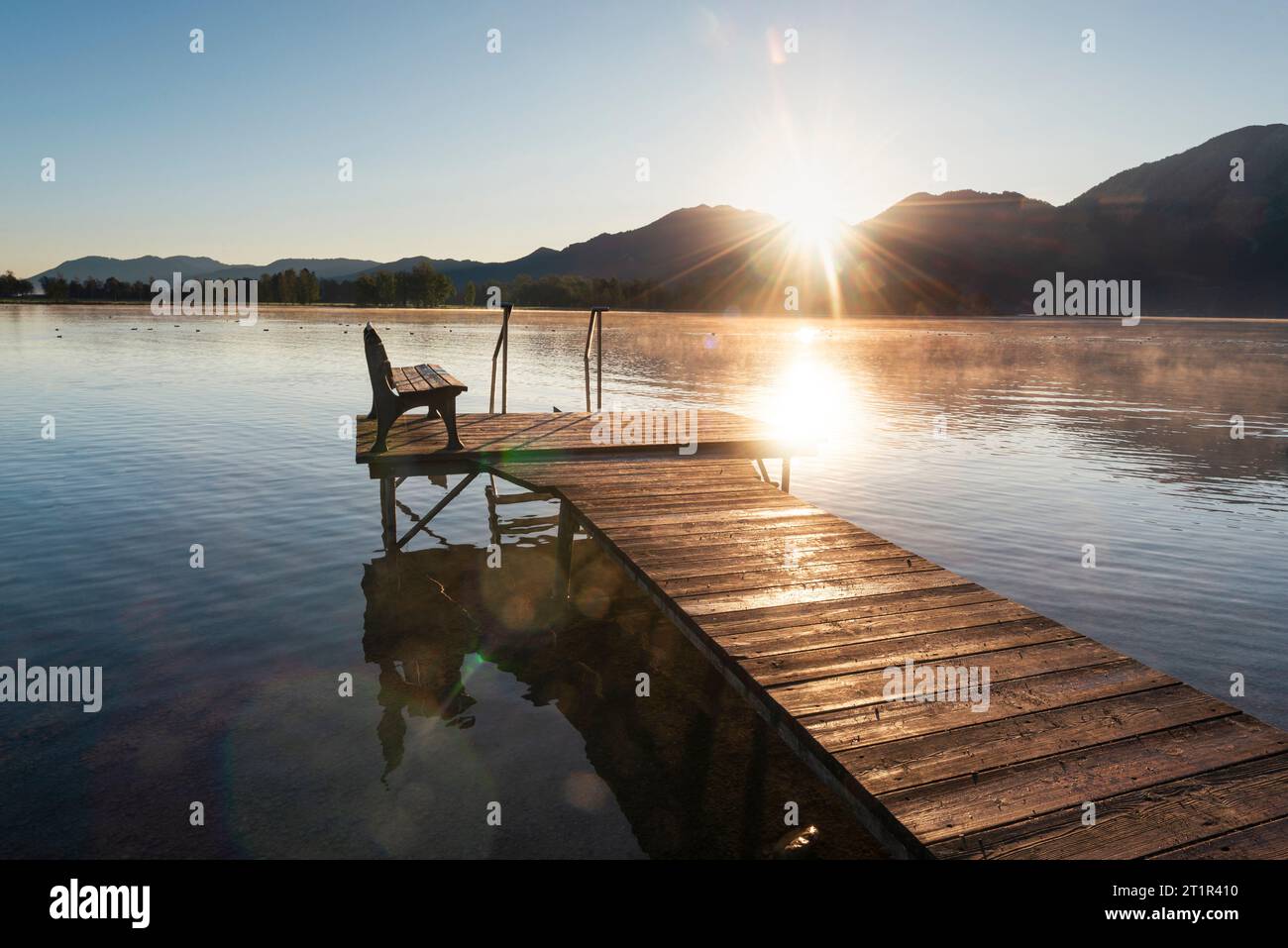 Sunrise over a wooden jetty on the shore of Lake Kochel in the pre-alps in autumn, Bavaria, Germany Stock Photo