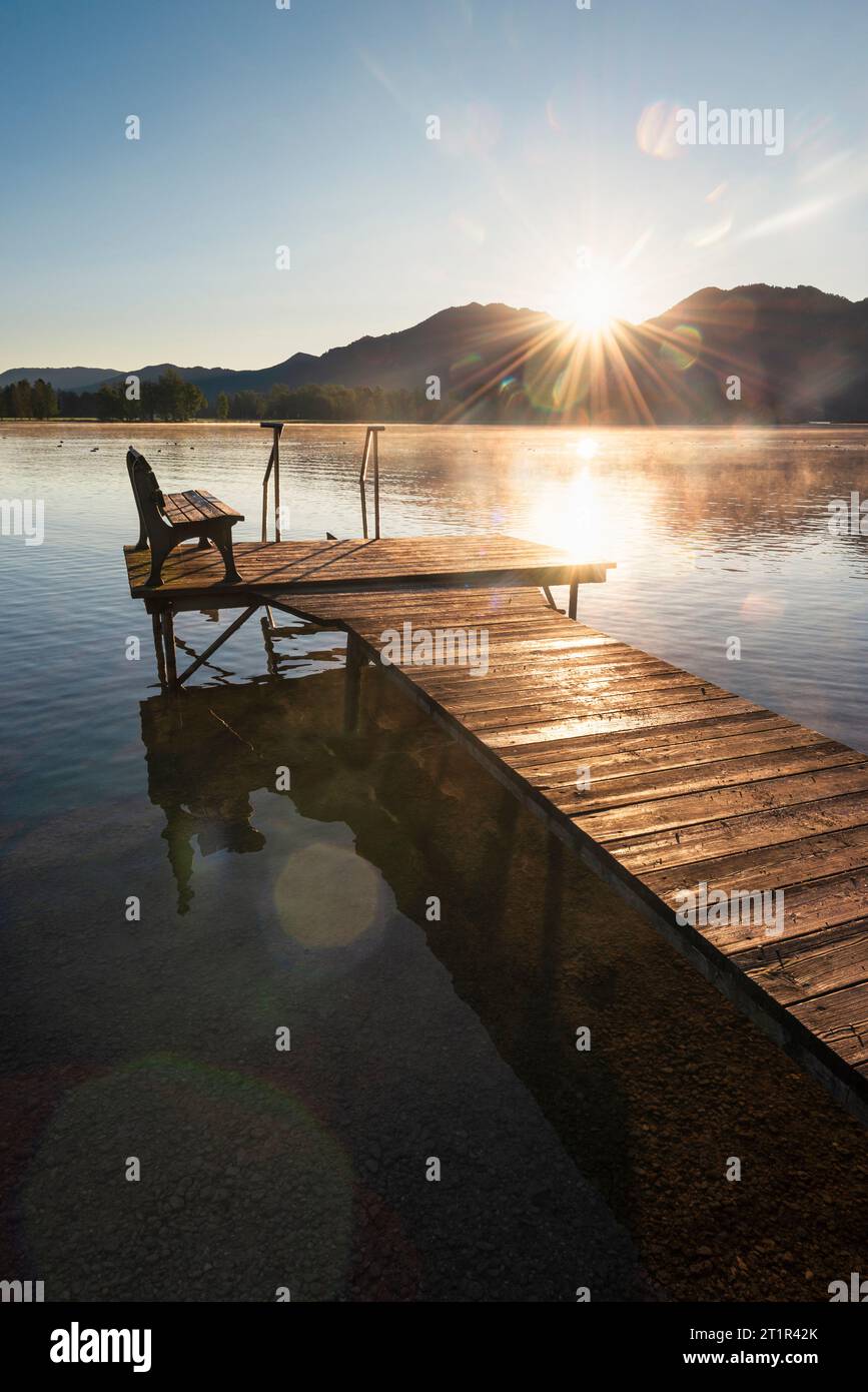 Sunrise over a wooden jetty on the shore of Lake Kochel in the pre-alps in autumn, Bavaria, Germany Stock Photo