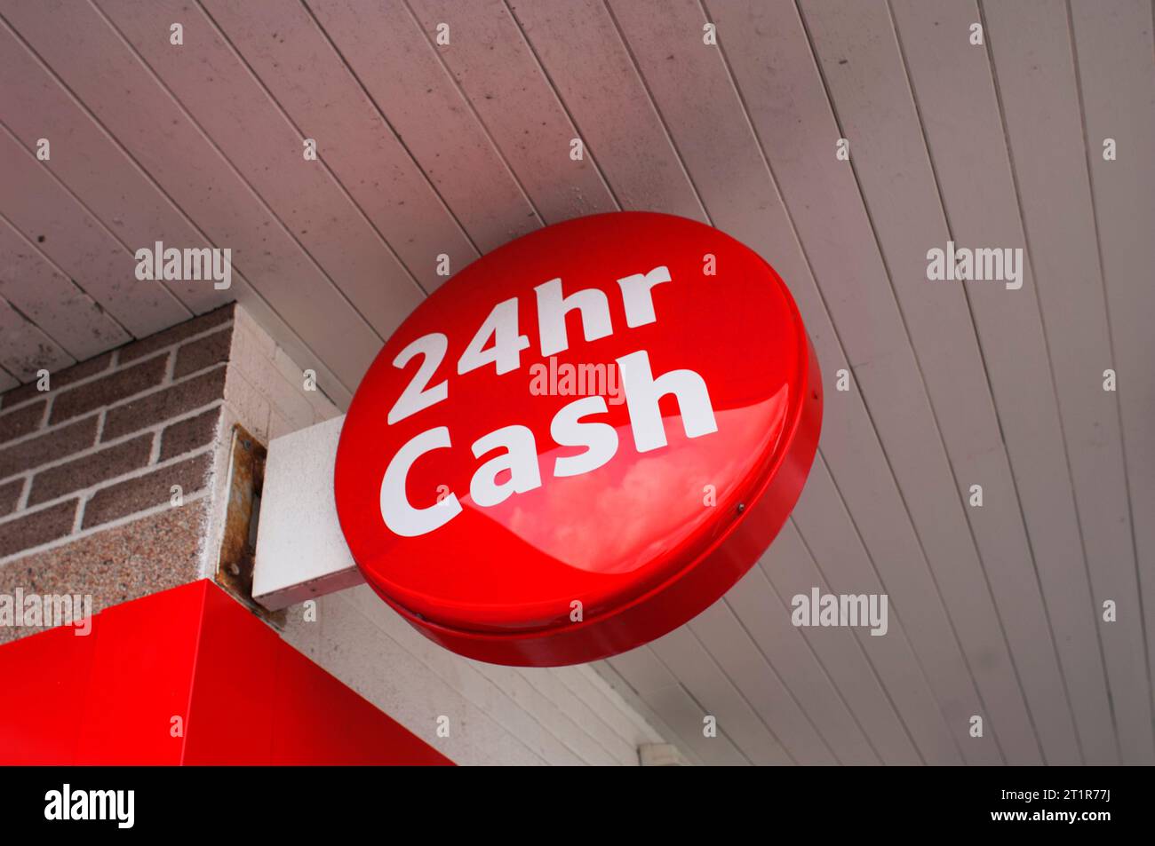 Red sign advertising a nearby ATM machine - John Gollop Stock Photo
