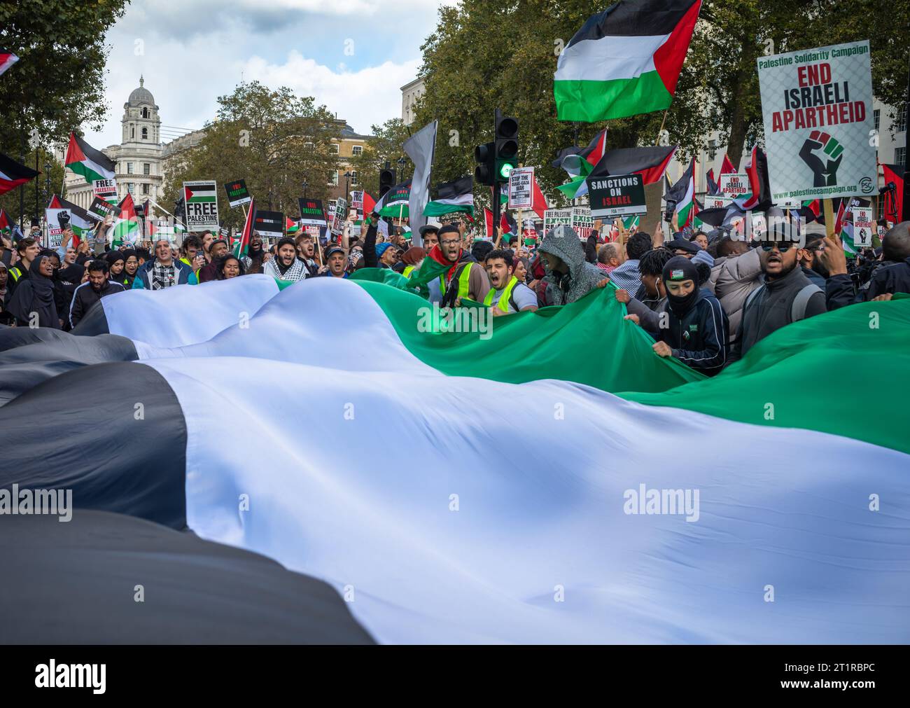 London, UK. 14 Oct 2023: Peaceful pro-Palestinian protesters hold a ginat Palestinian flag in Whitehall in central London, UK, at a demonstration agai Stock Photo