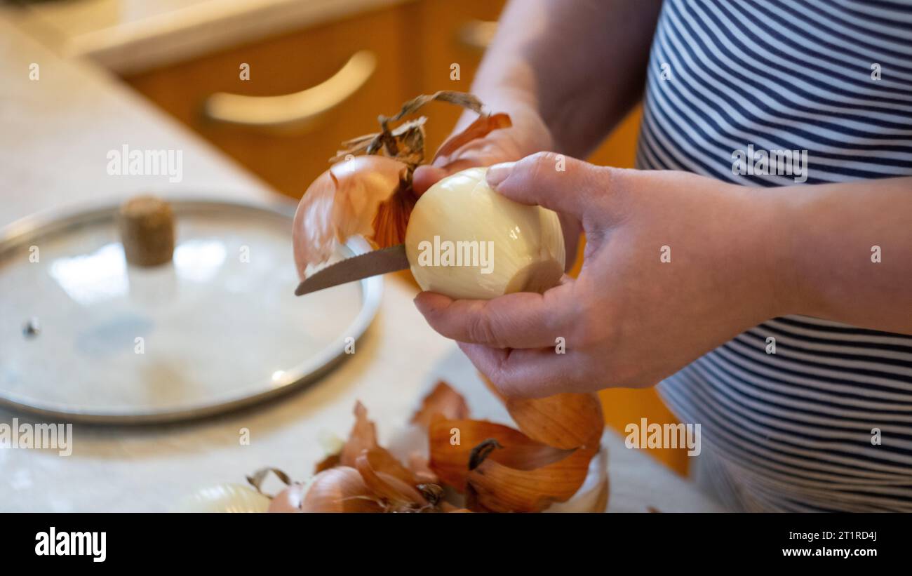 Woman peeling onion table hi-res stock photography and images - Alamy