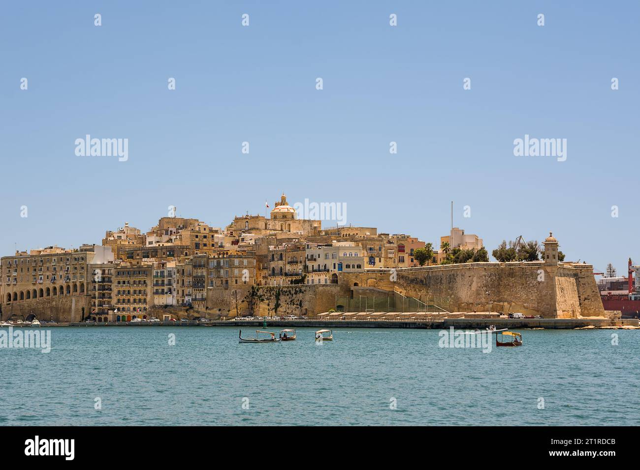 Valletta, Malta - 17 June 2023: Gulf between Valletta and Vittoriosa with passing boats and typical luzzu and Vittoriosa in the background Stock Photo