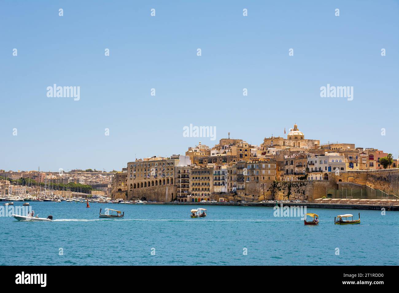 Valletta, Malta - 17 June 2023: Gulf between Valletta and Vittoriosa with passing boats and typical luzzu and Vittoriosa in the background Stock Photo