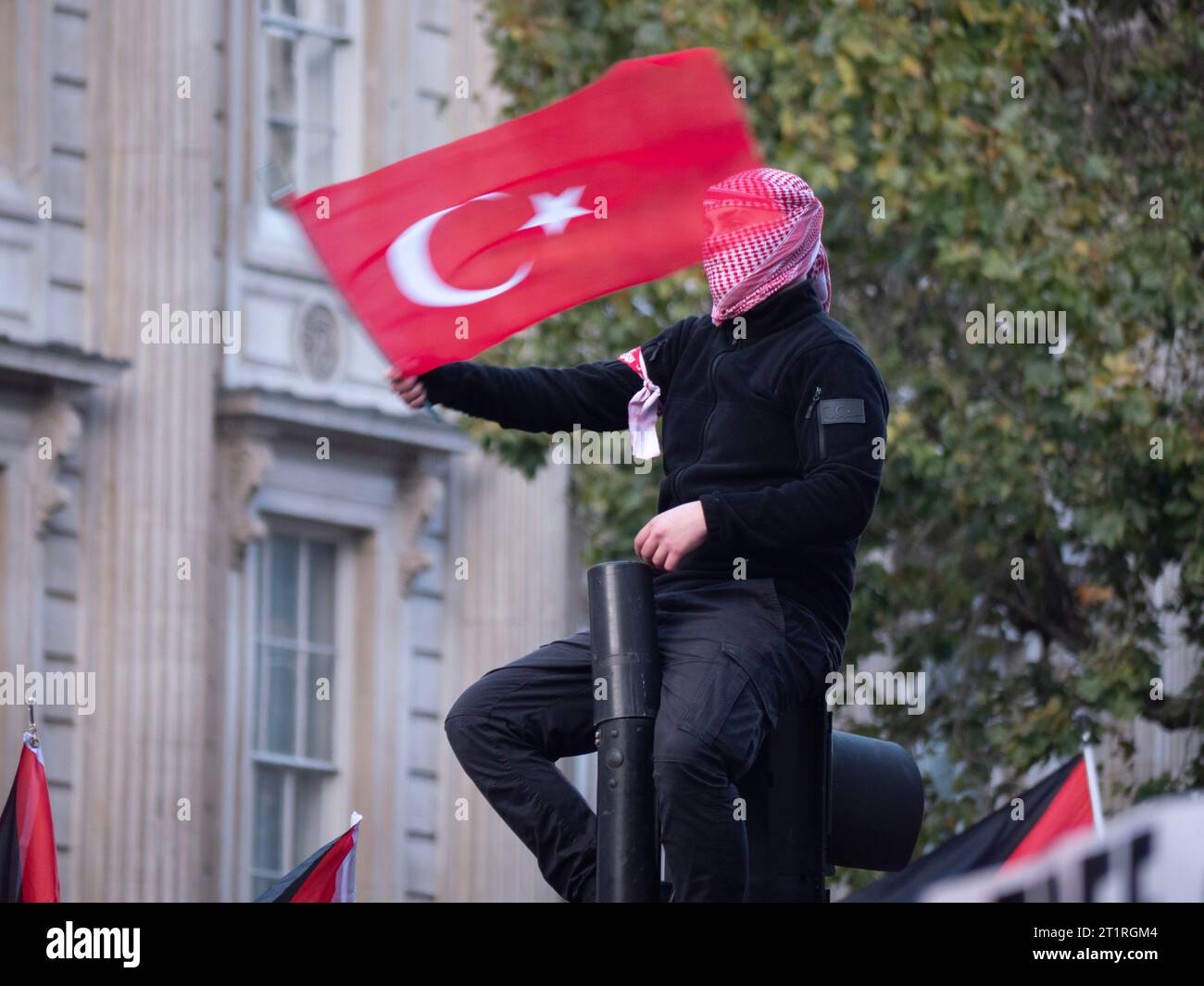 Protestor with Turkish Flag, flag of Turkey at Pro-Palestinian march in London, UK, at the Palestine Solidarity Campaign demonstration, march was organised to protest about the Israel Palestine confict over the Gaza Strip Stock Photo