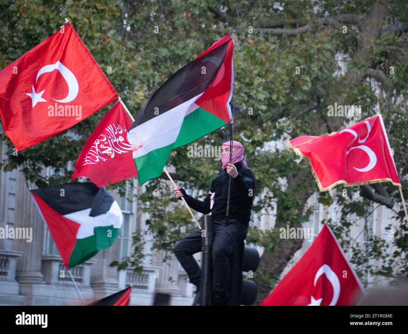 Protestor with Palestinian Flag and  Turkish Flag, flag of Turkey and flag of Palestine,  at Pro-Palestinian march in London, UK, at the Palestine Solidarity Campaign demonstration, march was organised to protest about the Israel Palestine confict over the Gaza Strip Stock Photo