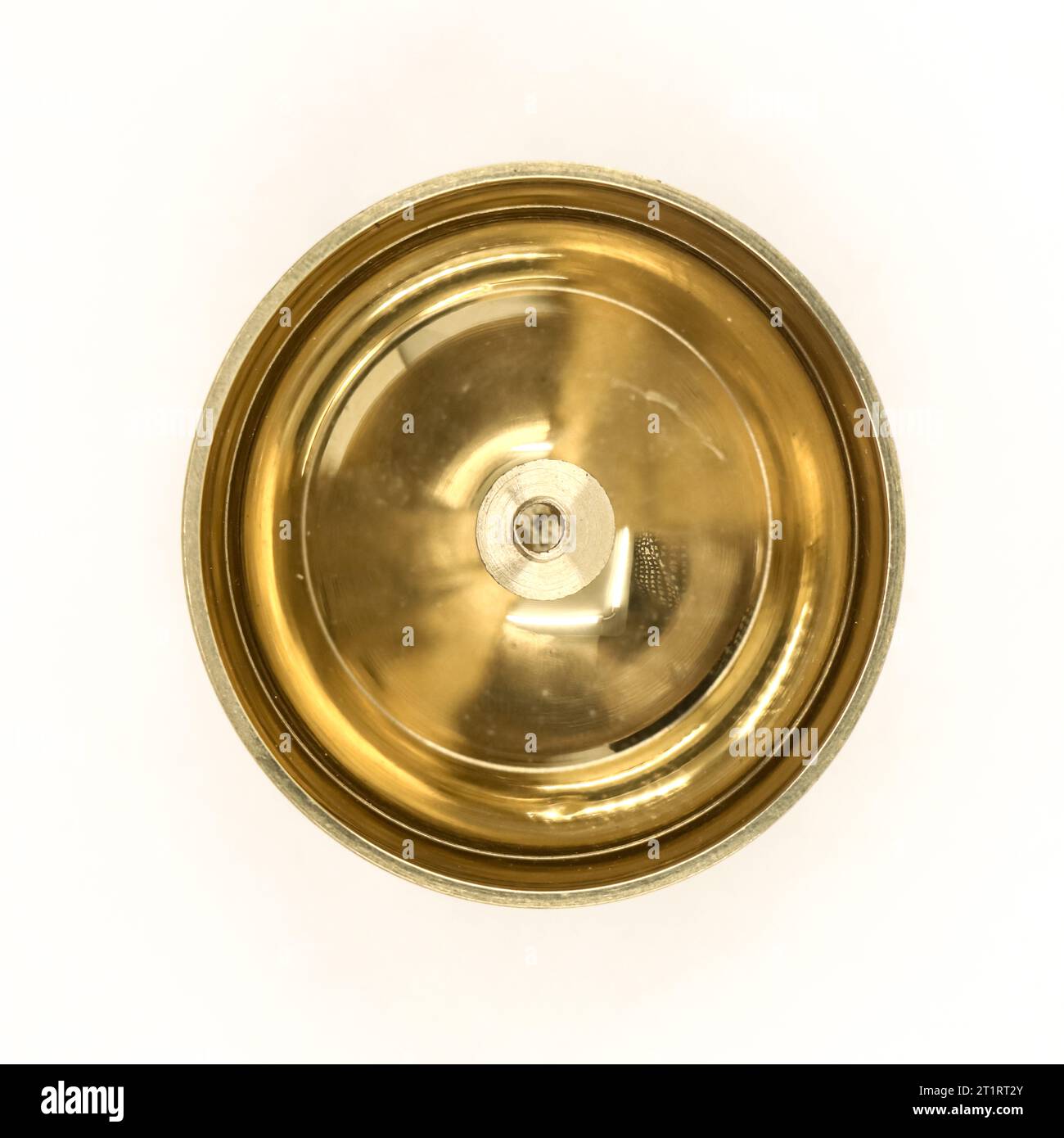 a shiny round brass oil lamp with wick holder isolated in a white