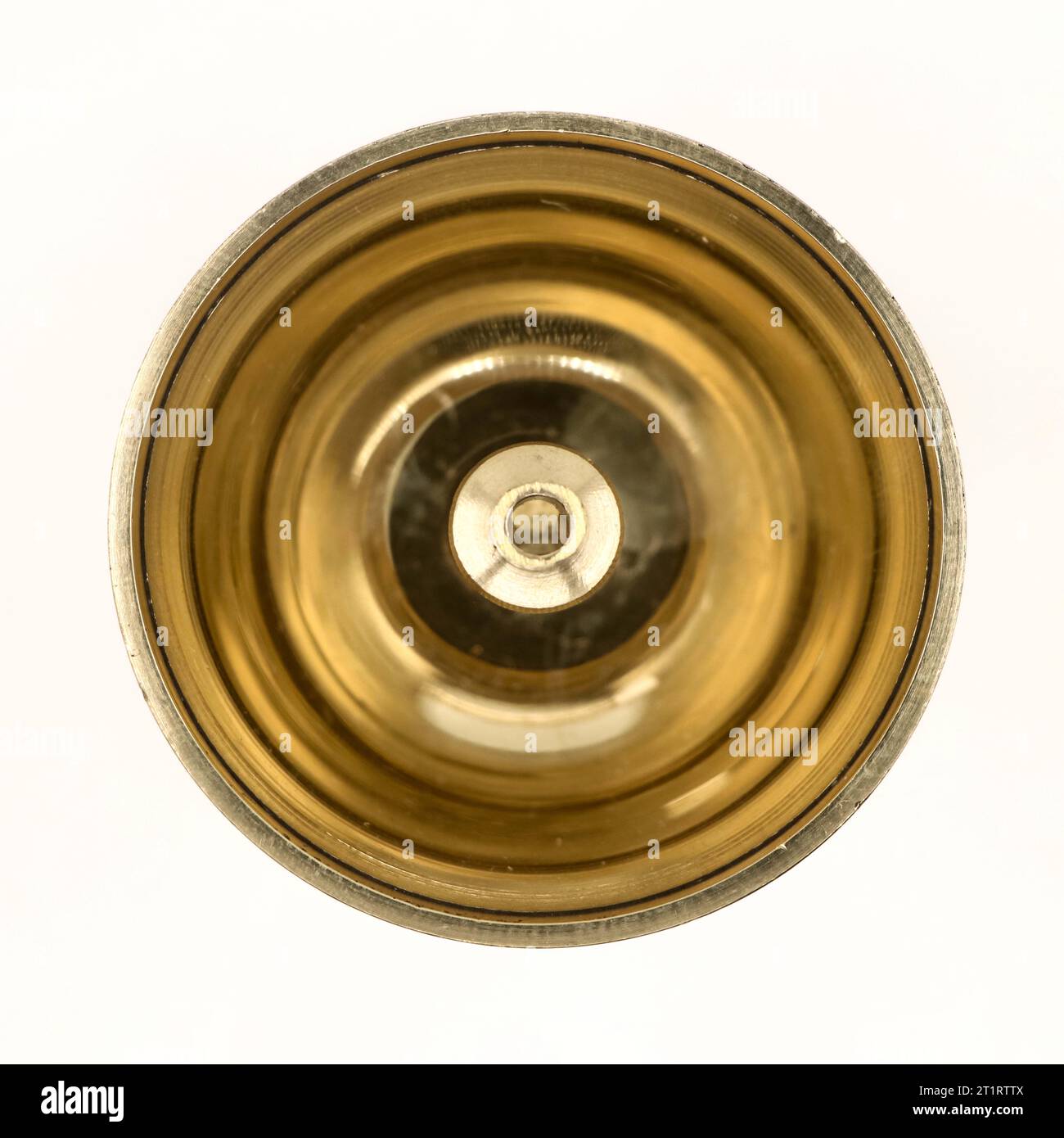 a shiny round brass oil lamp with wick holder isolated in a white