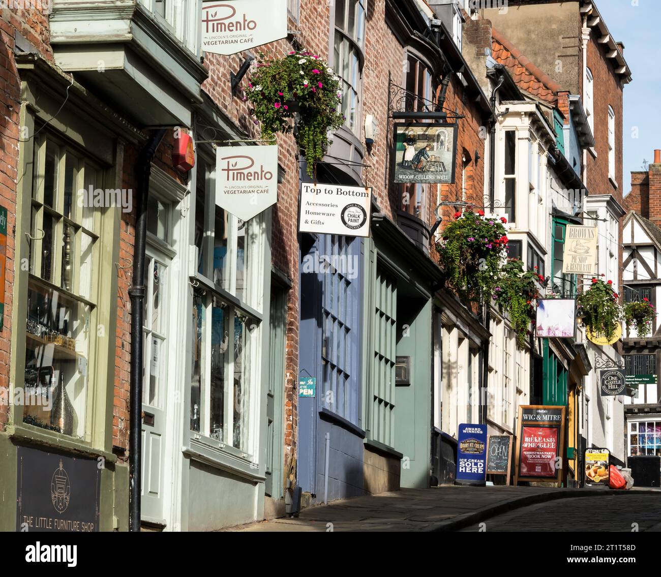 Independant shops west side of Steep Hill in midday sun autumn, Steep Hill, Lincoln City, Lincolnshire, England, UK Stock Photo