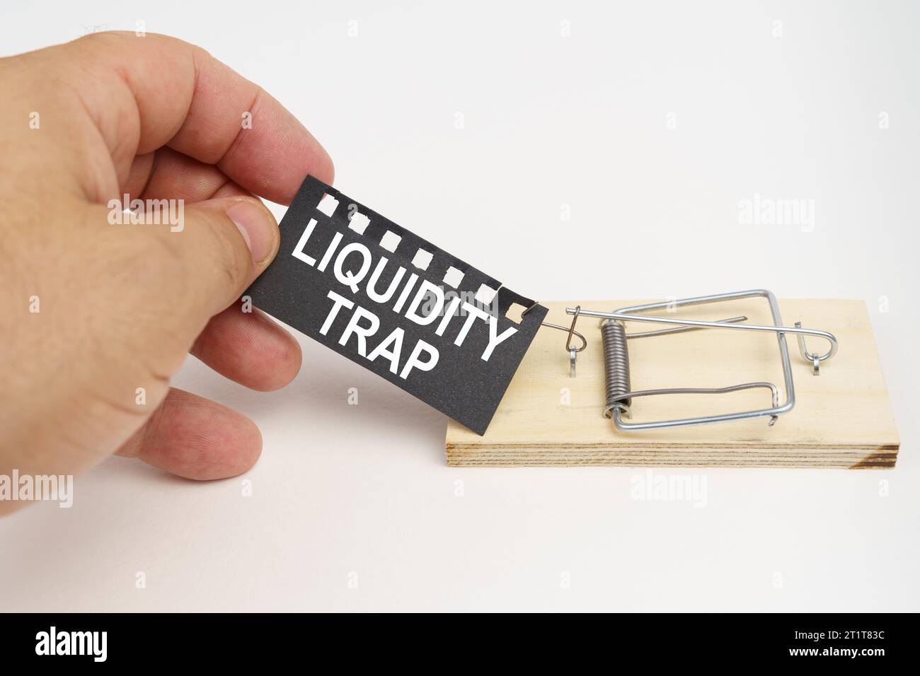 A man pulls the bait from a mousetrap. Bait, a sheet of black paper