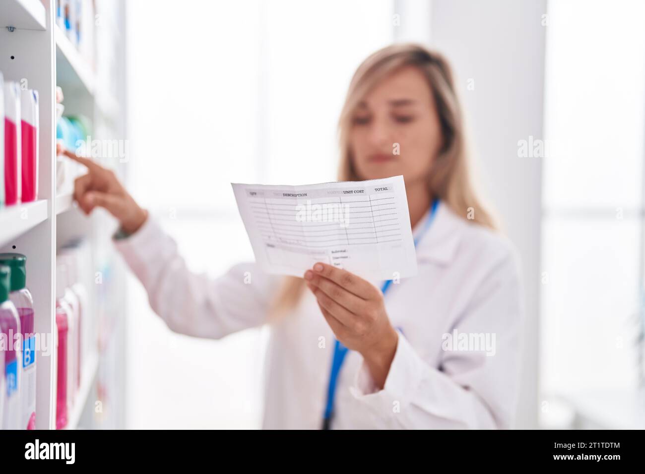 Young blonde woman pharmacist reading prescription at pharmacy Stock ...