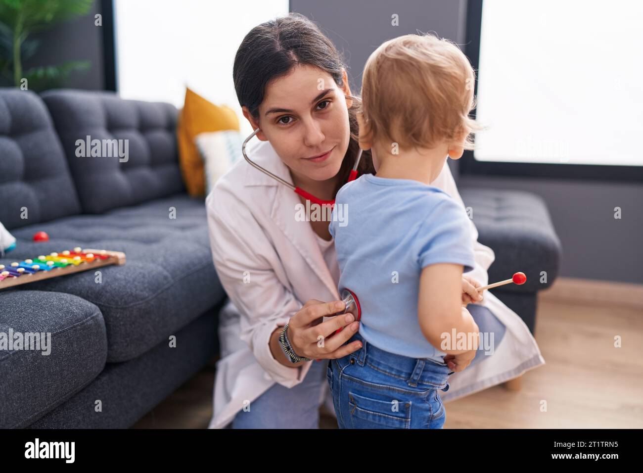 Mother and son doctor examining child at home Stock Photo - Alamy