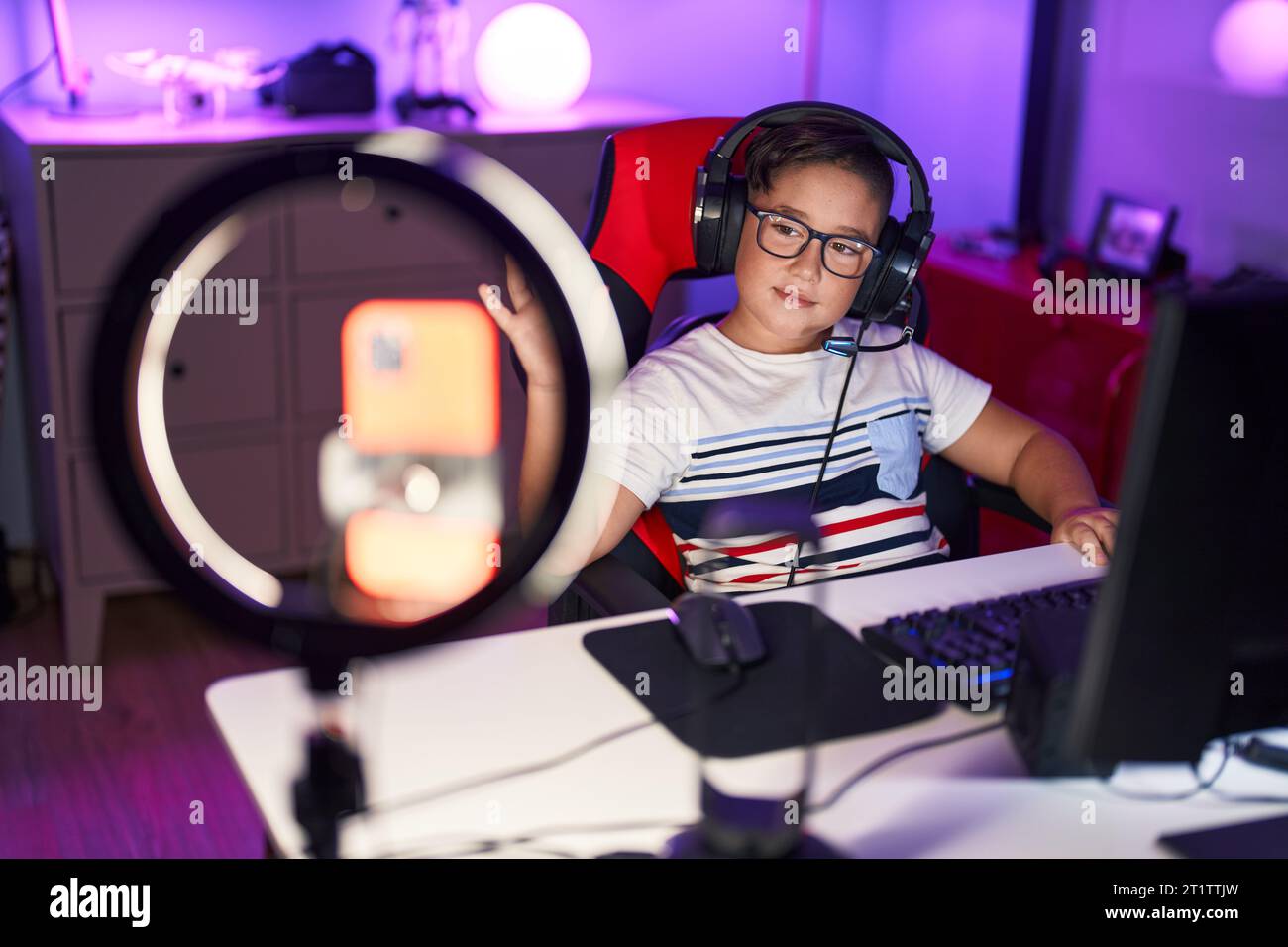 Young hispanic kid playing video games looking positive and happy ...