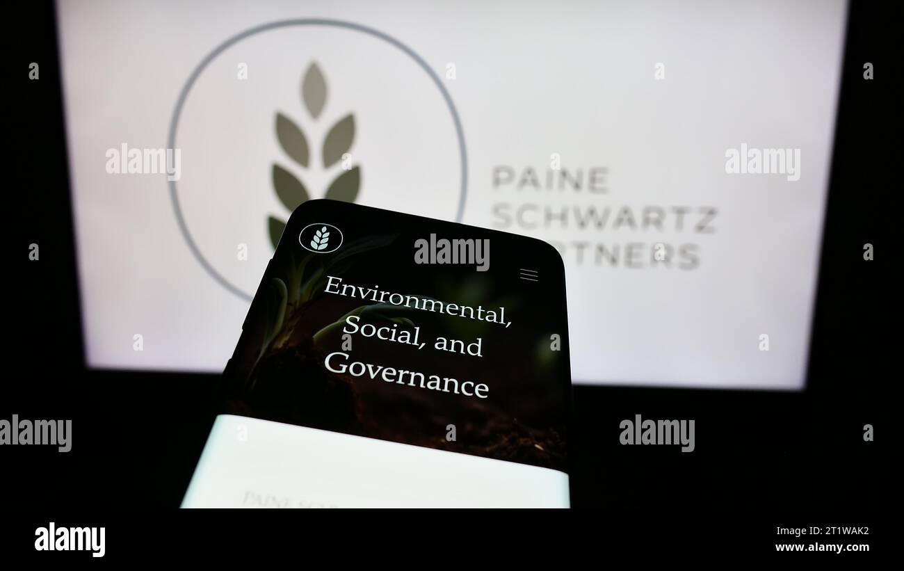 Smartphone with website of US investment company Paine Schwartz Partners LLC in front of business logo. Focus on top-left of phone display. Stock Photo