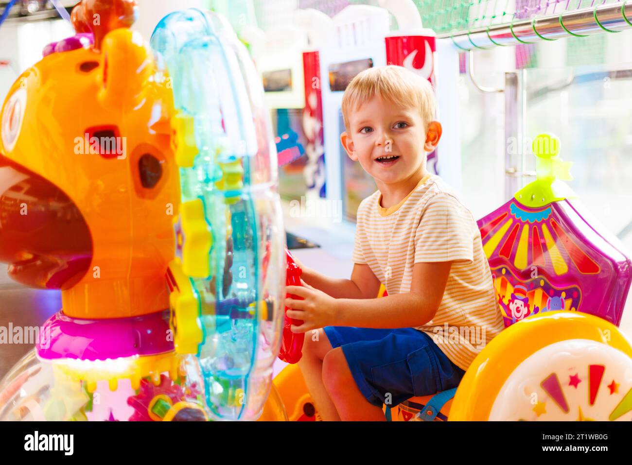 A child rides on electric riding toy at an amusement park Stock Photo ...