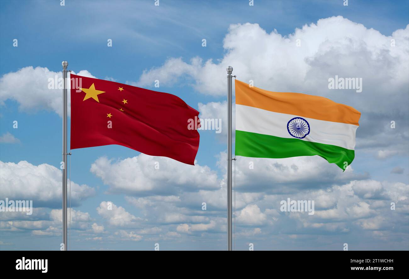 India and China flags waving together on blue cloudy sky, two country relationship concept Stock Photo