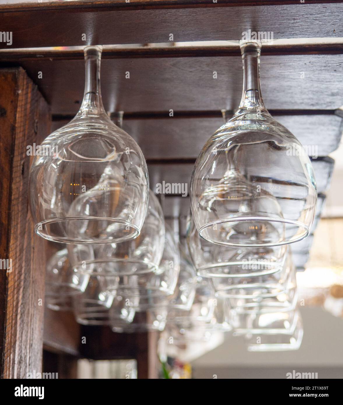 Glasses hang over the bar counter. The glasses are turned upside down