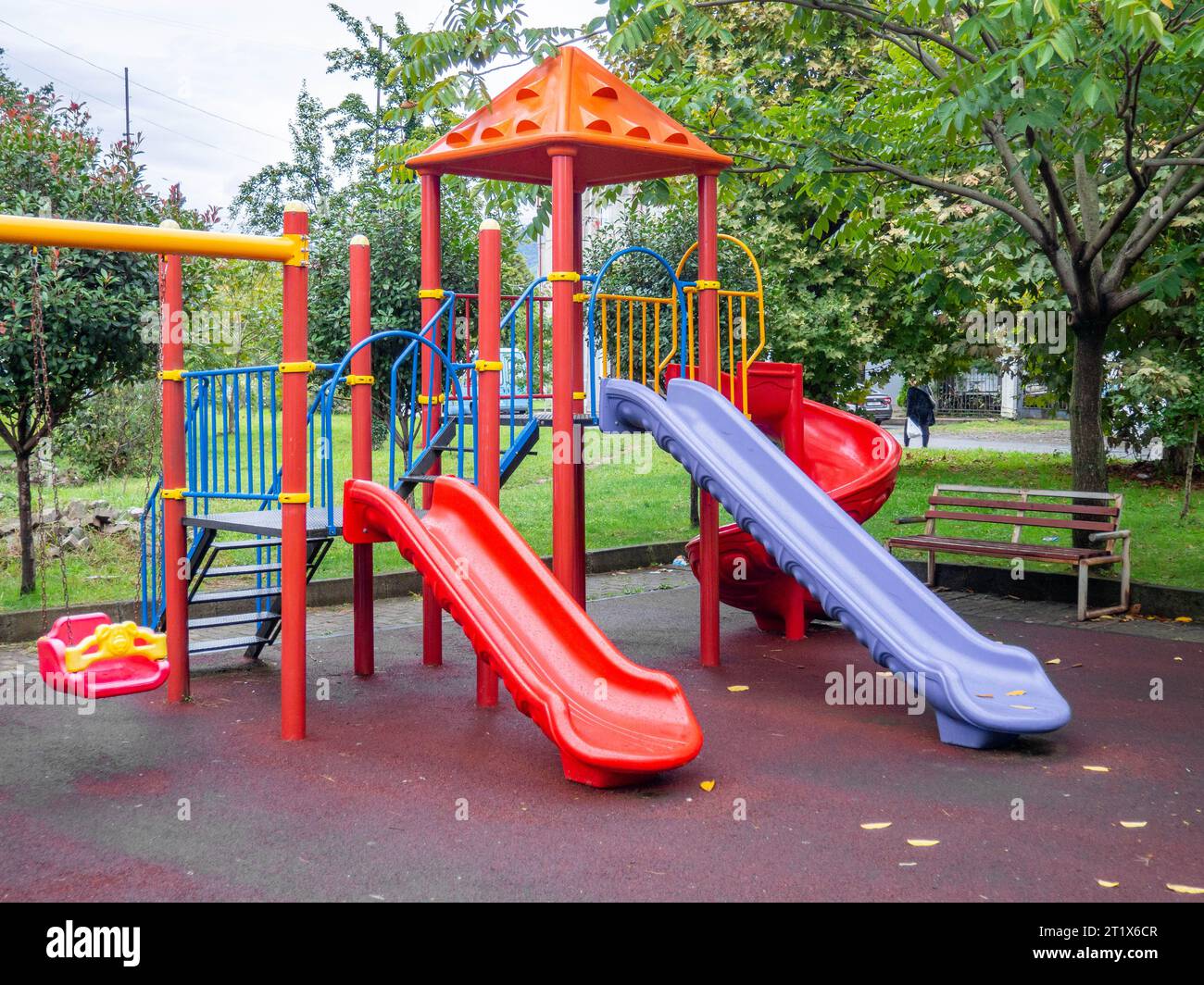 Plastic playground. Safe game for children. City infrastructure. Swings and slides made of plastic. Entertainment. Playground in the yard. Spiral slid Stock Photo